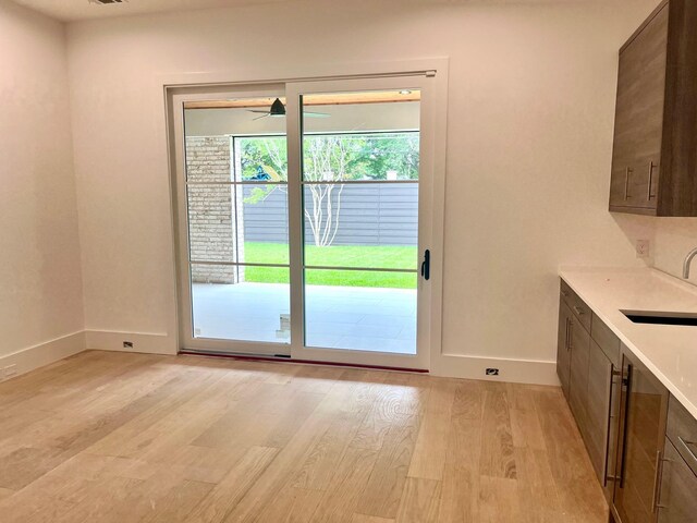 5808 Brookstown Dr, Dallas, TX 75230 - doorway to outside featuring a sink, baseboards, light wood-style floors, and ceiling fan