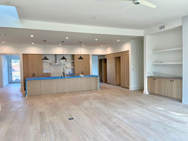 kitchen featuring light hardwood / wood-style floors, a large island, ceiling fan, light brown cabinets, and pendant lighting