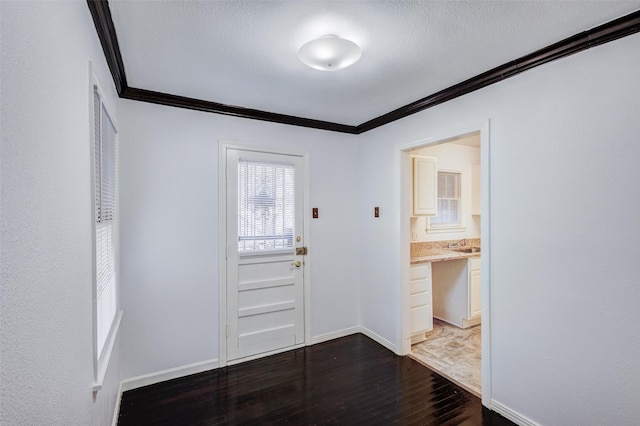 doorway featuring a textured ceiling, crown molding, hardwood / wood-style floors, and sink