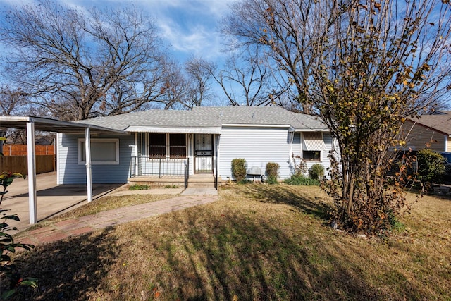 ranch-style home with covered porch, a front lawn, and a carport