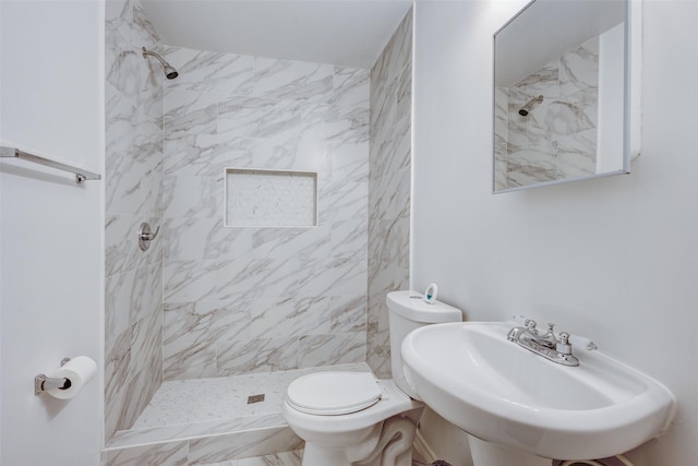 bathroom featuring sink, toilet, and tiled shower