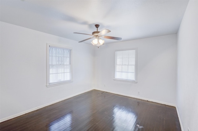 unfurnished room featuring ceiling fan, a wealth of natural light, and dark hardwood / wood-style floors