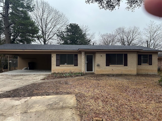 ranch-style home featuring a carport, driveway, and brick siding