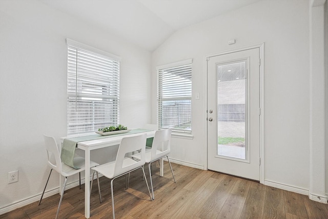 dining room featuring vaulted ceiling and light hardwood / wood-style floors