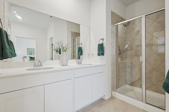 bathroom with walk in shower, vanity, and tile patterned flooring