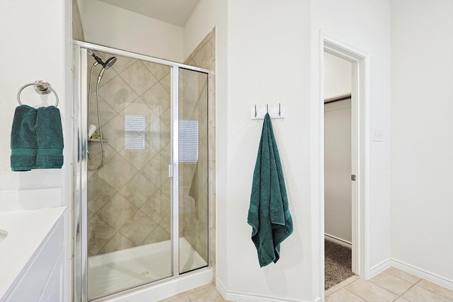 bathroom with tile patterned floors, walk in shower, and vanity