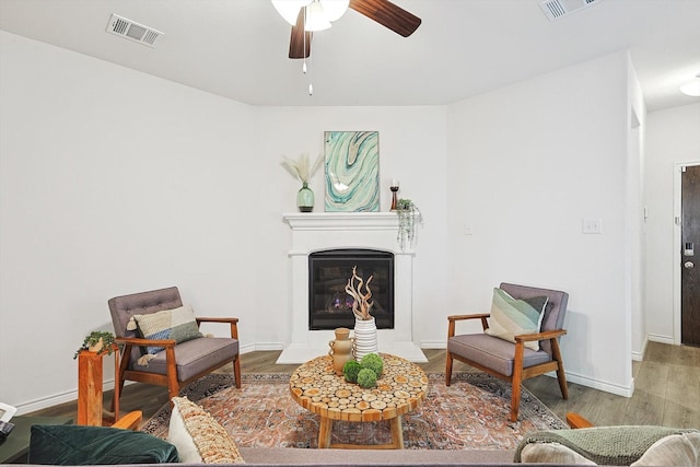 sitting room with ceiling fan and hardwood / wood-style floors