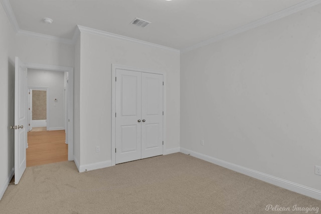 unfurnished bedroom with light carpet, a closet, and ornamental molding