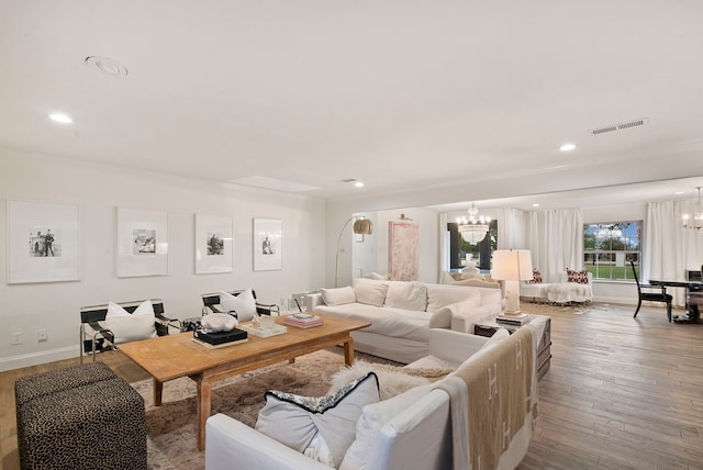 living room with hardwood / wood-style flooring and a notable chandelier