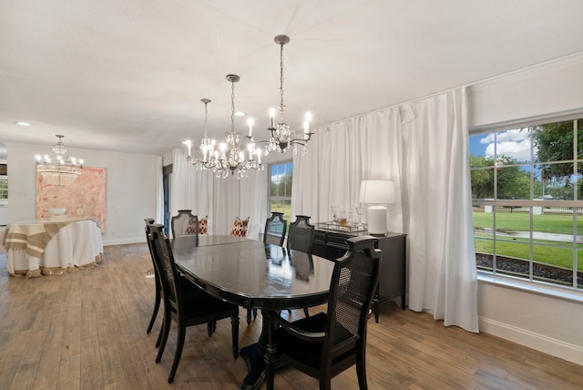 dining space featuring hardwood / wood-style floors and an inviting chandelier