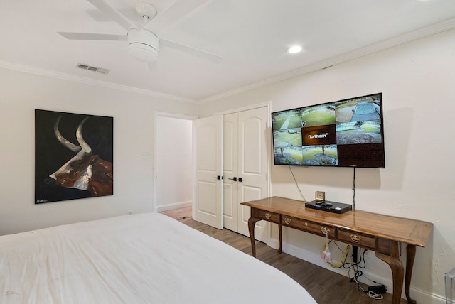 bedroom featuring ceiling fan, ornamental molding, a closet, and dark hardwood / wood-style floors