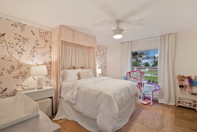 bedroom featuring dark wood-type flooring, ceiling fan, and ornamental molding