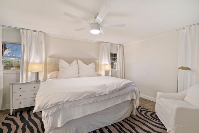 bedroom featuring ceiling fan, dark hardwood / wood-style flooring, ornamental molding, and multiple windows