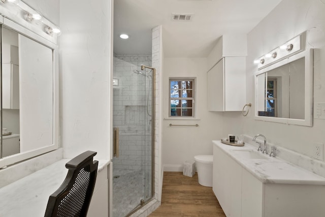 bathroom with toilet, wood-type flooring, walk in shower, and vanity