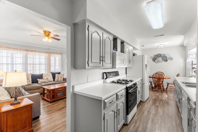 kitchen featuring ceiling fan, white appliances, wood-type flooring, and gray cabinetry