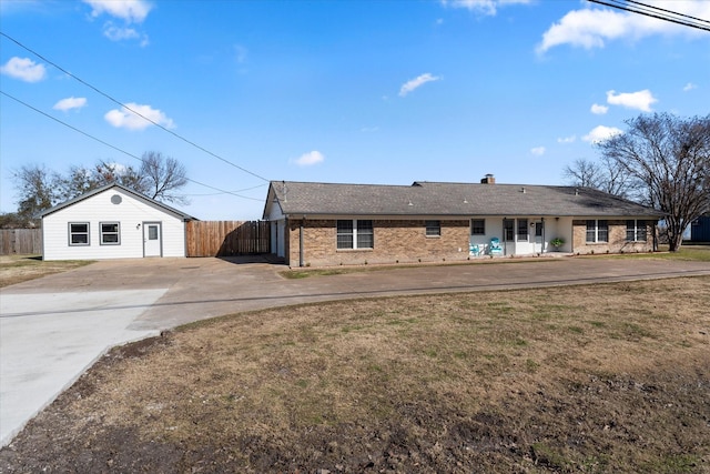 view of front facade featuring driveway, a front lawn, fence, brick siding, and a chimney