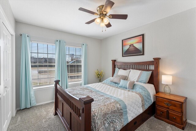 carpeted bedroom featuring ceiling fan, multiple windows, and a closet