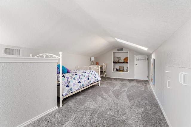 carpeted bedroom with a textured ceiling and vaulted ceiling with skylight