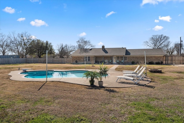 view of swimming pool with a diving board, a lawn, and a patio