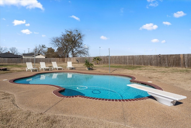 view of pool with a diving board and a patio area