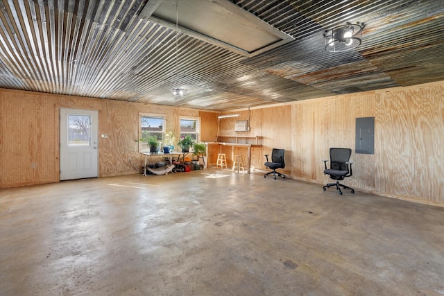 garage with electric panel and wooden walls