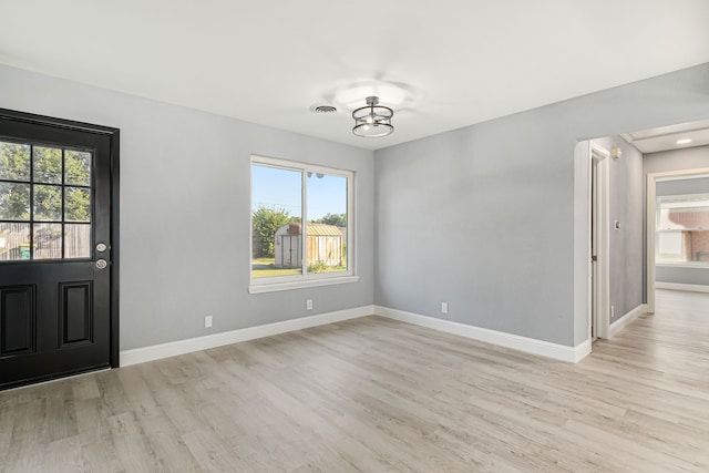 foyer with a chandelier and light hardwood / wood-style flooring