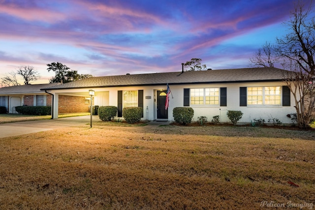 ranch-style house featuring a yard and a carport