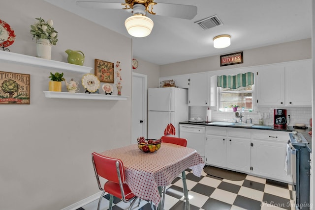 kitchen featuring decorative backsplash, sink, white cabinets, and white appliances