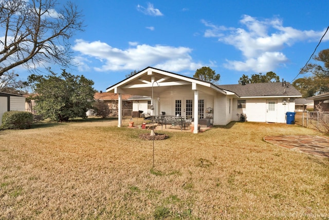 rear view of house with a patio and a yard