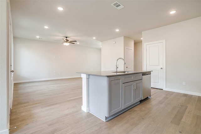 kitchen with gray cabinets, dishwasher, sink, a kitchen island with sink, and light wood-type flooring