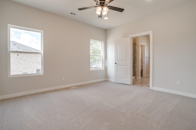 empty room featuring light colored carpet and ceiling fan