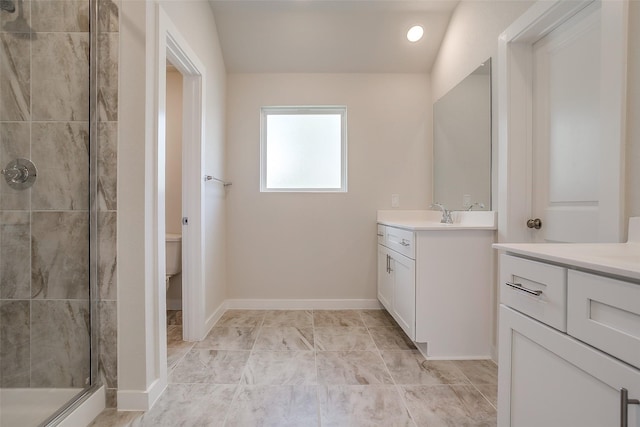 bathroom with vanity, vaulted ceiling, toilet, and tiled shower