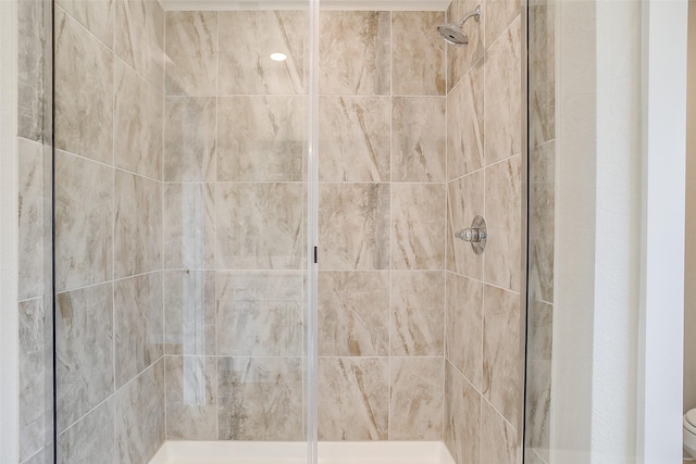 bathroom featuring a tile shower and toilet