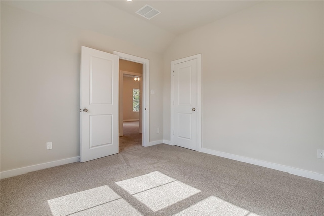 spare room with vaulted ceiling and carpet floors