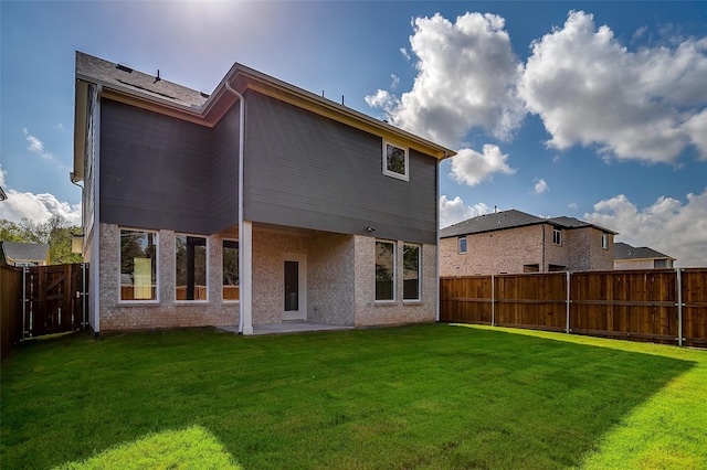 rear view of house featuring a patio area and a lawn