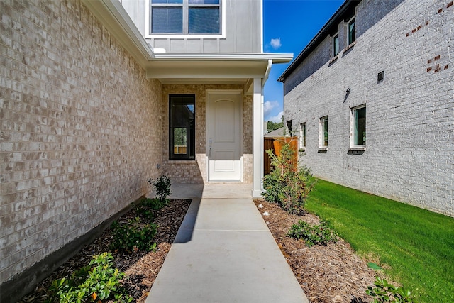 entrance to property featuring a lawn