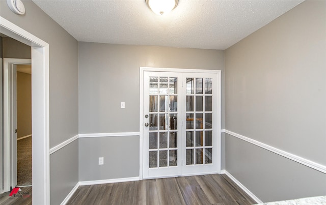 spare room with a textured ceiling and dark wood-type flooring