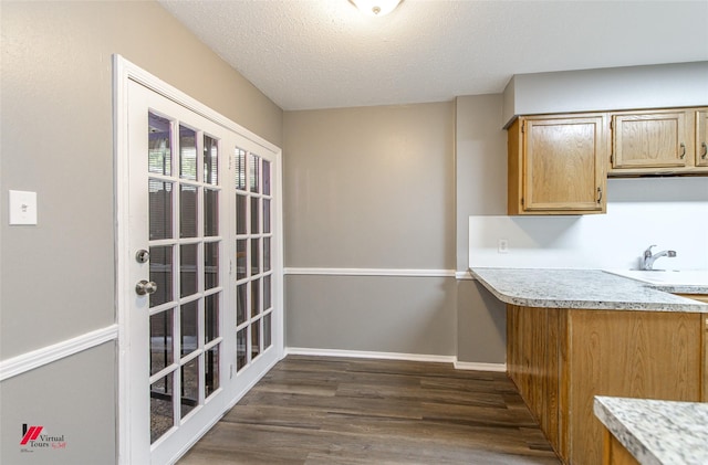 kitchen featuring dark wood-type flooring, sink, and a textured ceiling