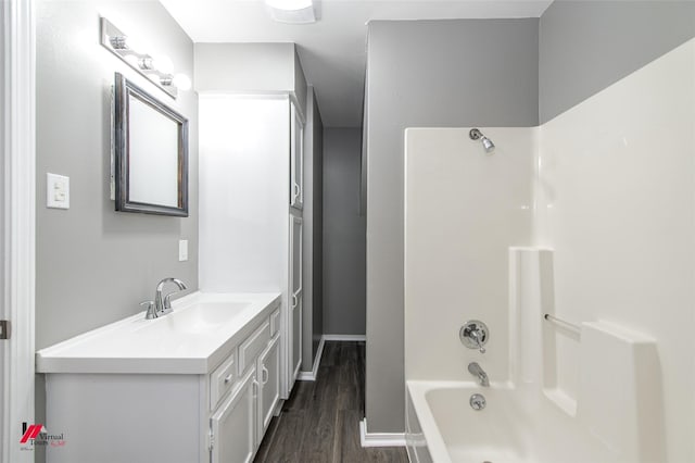 bathroom with hardwood / wood-style floors, shower / tub combination, and vanity