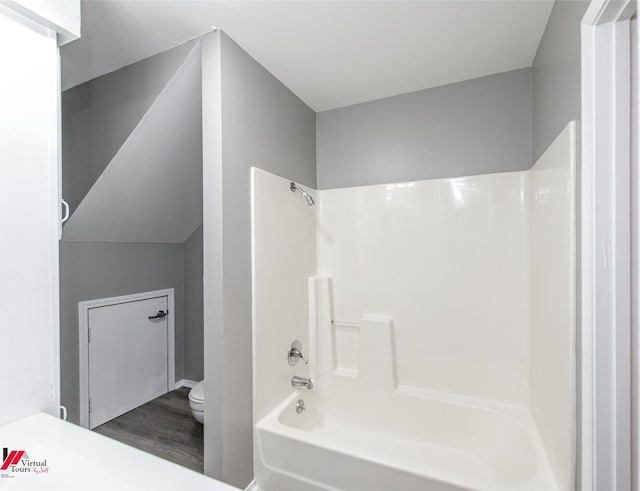 bathroom with toilet, shower / bathtub combination, and hardwood / wood-style floors