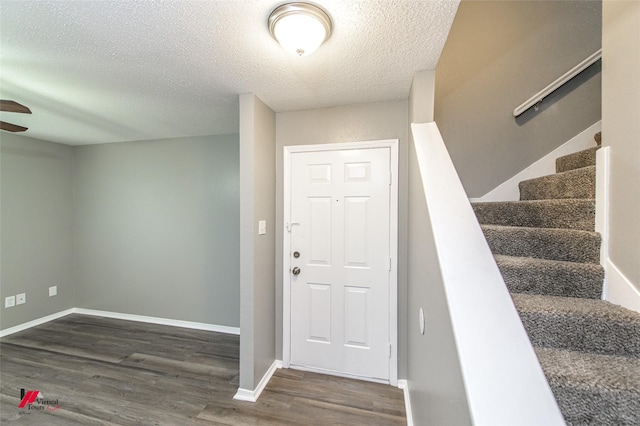 foyer featuring dark hardwood / wood-style flooring and a textured ceiling