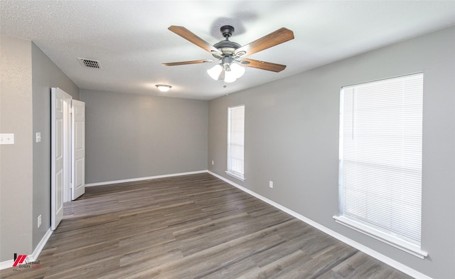 spare room featuring a textured ceiling, ceiling fan, and dark hardwood / wood-style flooring