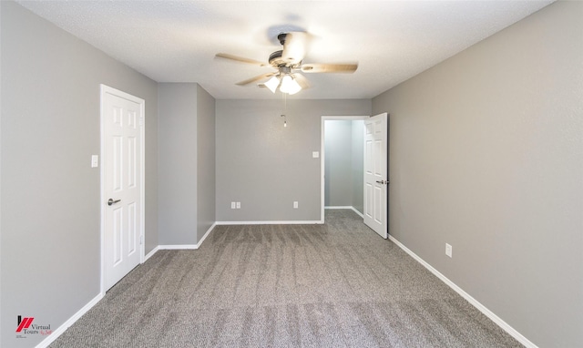 spare room with ceiling fan and carpet