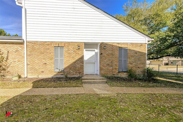 doorway to property with a lawn