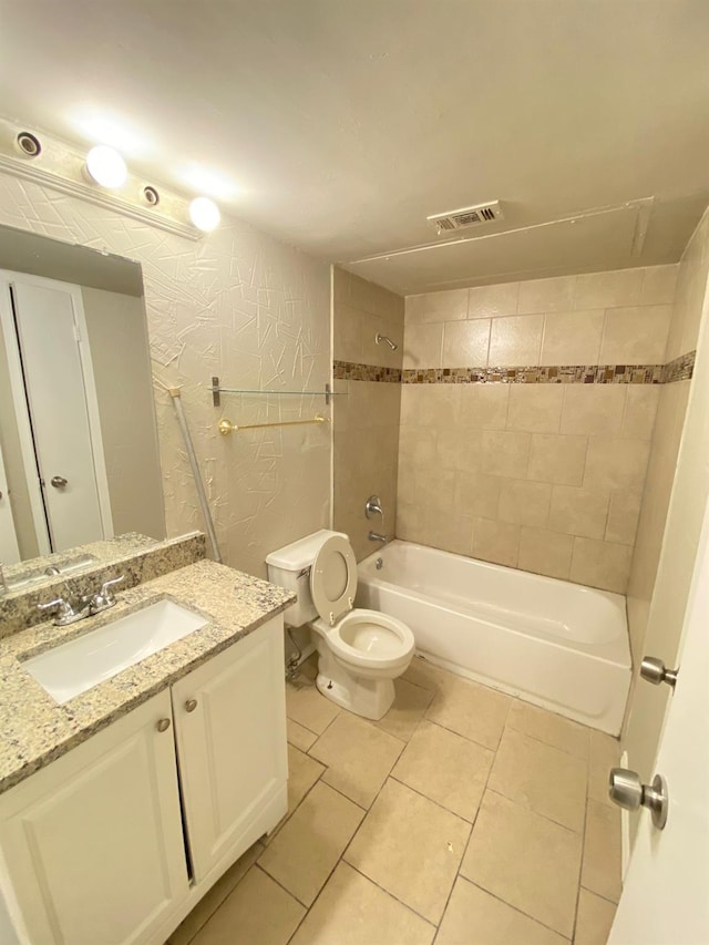 full bathroom with toilet, tile patterned floors, tiled shower / bath, and vanity