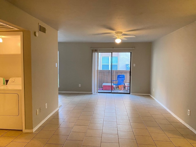 tiled spare room with ceiling fan and separate washer and dryer