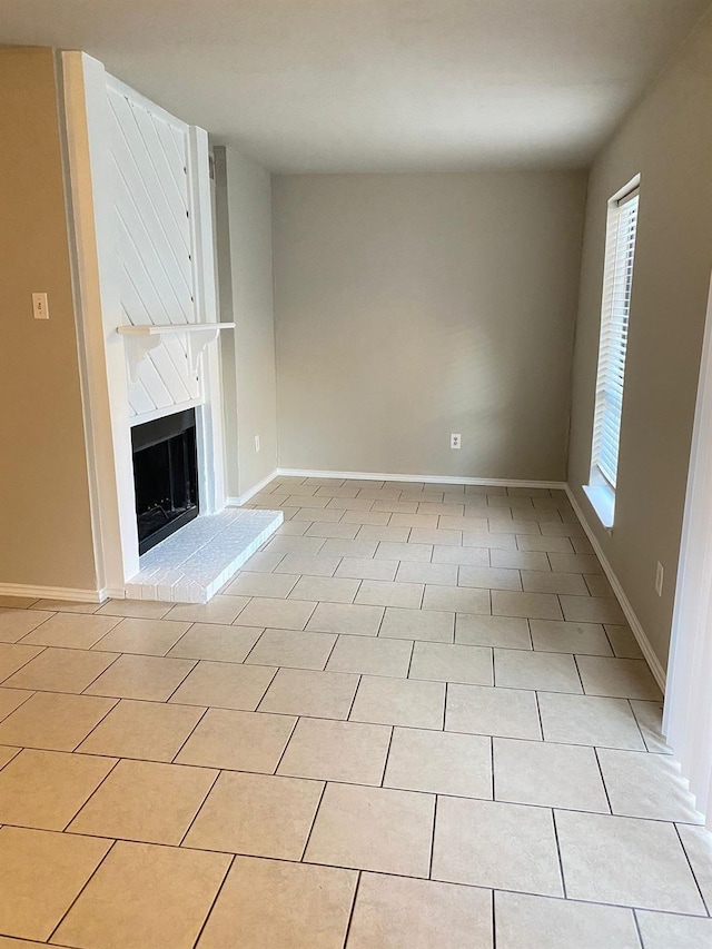 unfurnished living room with light tile patterned flooring and a healthy amount of sunlight