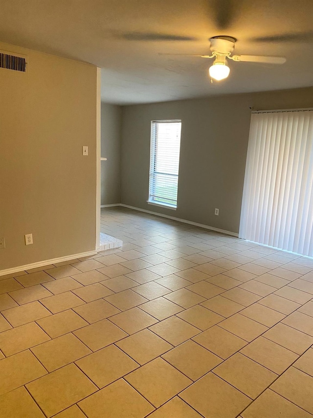 spare room with ceiling fan and light tile patterned floors