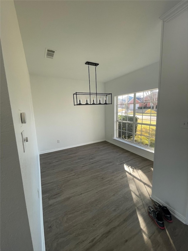 unfurnished dining area with dark wood-type flooring