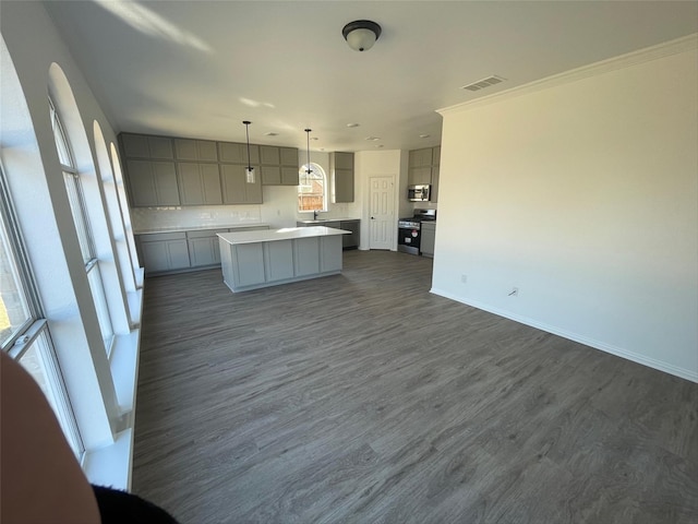 kitchen with dark hardwood / wood-style floors, pendant lighting, a kitchen island, appliances with stainless steel finishes, and gray cabinetry